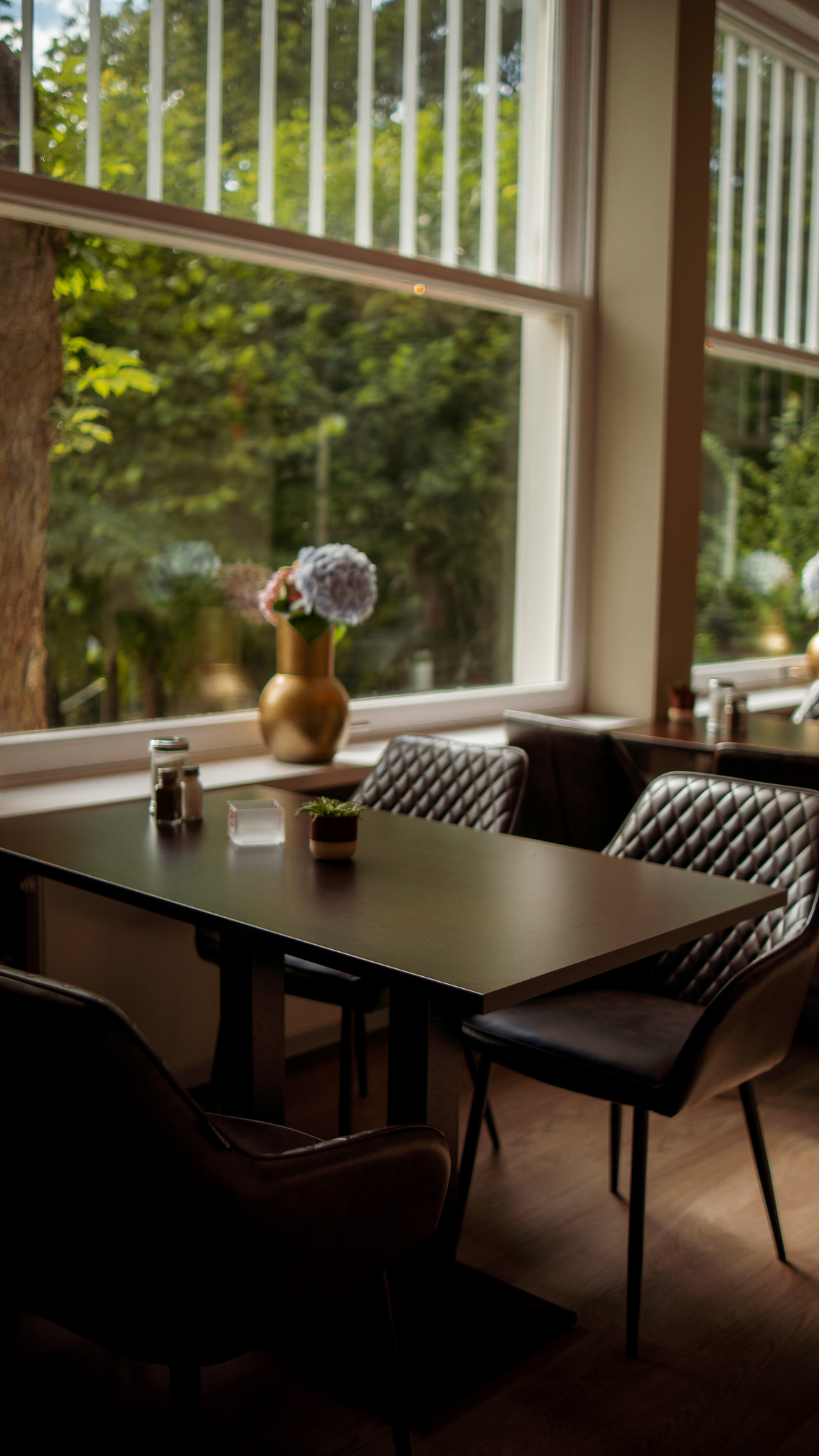 Gemütliches Restaurant-Interieur mit Fenstertisch und Gartenblick