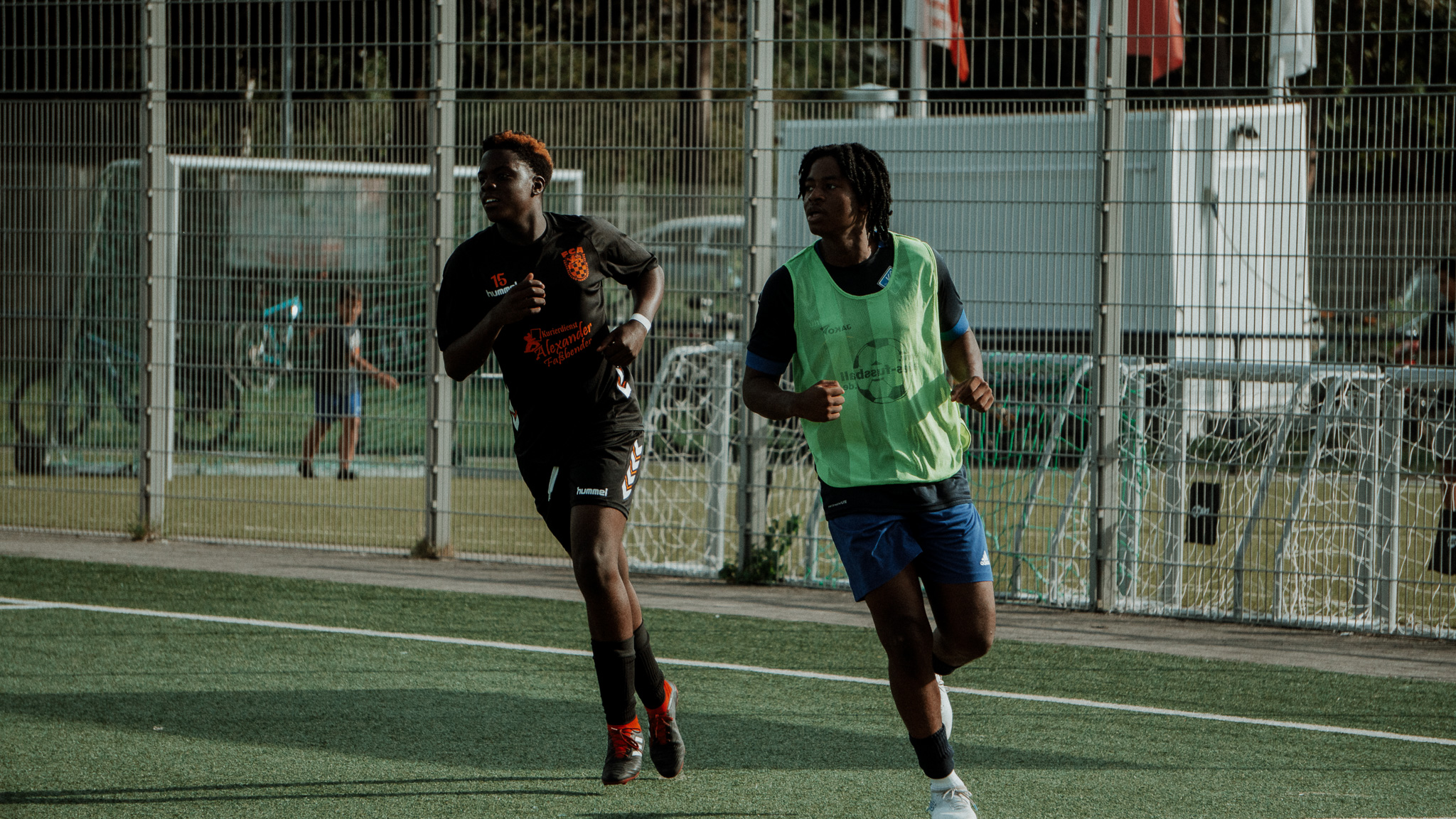 Zwei Fußballspieler beim Abendtraining auf beleuchtetem Platz